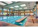 Indoor swimming pool with lap lanes, lounge chairs, and ample natural light at 2349 Orangeburg Pl, Henderson, NV 89044