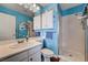 Bright blue bathroom with white cabinets, a walk-in shower, and modern fixtures at 3055 Whispering Crest Dr, Henderson, NV 89052