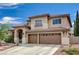 Inviting two-story home featuring a tile roof, three-car garage, and low-maintenance landscaping at 3055 Whispering Crest Dr, Henderson, NV 89052