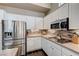 This kitchen features stainless steel appliances, white cabinets, tile backsplash, and granite countertops at 3055 Whispering Crest Dr, Henderson, NV 89052