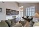 Bright living room featuring dark floors, neutral paint and a decorative brick accent wall at 3055 Whispering Crest Dr, Henderson, NV 89052