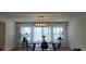 Bright dining area with a modern chandelier, sheer curtains, and a wooden table for meals at 314 W Winston Ln, Indian Springs, NV 89018