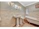 Charming bathroom featuring a pedestal sink, vintage mirror, and clawfoot bathtub at 3141 E Katie Ave, Las Vegas, NV 89121