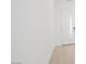 Minimalist hallway with white walls, hardwood flooring, and a sleek white door, providing a clean aesthetic at 350 Tigullio Ave, Henderson, NV 89011