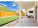Covered patio area overlooking a backyard with artificial grass and a secure wrought iron fence at 3630 Daisy Field Dr, North Las Vegas, NV 89032