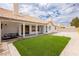 Backyard featuring a covered patio, small patch of artificial grass and string lights at 3630 Daisy Field Dr, North Las Vegas, NV 89032
