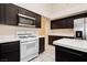 The kitchen offers white appliances, dark cabinets, and an island for food preparation at 3630 Daisy Field Dr, North Las Vegas, NV 89032