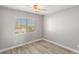 A bright bedroom featuring a ceiling fan, neutral walls, and a large window at 3709 Misty Falls St, Las Vegas, NV 89129
