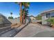 Backyard with hardscape and desert landscaping, featuring a brick-lined border and mature shade trees at 3791 El Camino Rd, Las Vegas, NV 89103