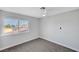 Bright bedroom features a ceiling fan, carpet, and a large window with neighborhood views at 3791 El Camino Rd, Las Vegas, NV 89103