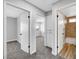 Bright hallway showcasing neutral walls, carpet, white doors, and an entrance to a full bathroom at 3791 El Camino Rd, Las Vegas, NV 89103