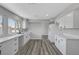 A bright kitchen featuring white cabinets, stone countertops, and wood floors at 3791 El Camino Rd, Las Vegas, NV 89103