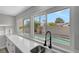 Modern kitchen with white cabinets, sleek countertops, a stylish faucet and views of the private pool at 3791 El Camino Rd, Las Vegas, NV 89103