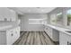 A kitchen featuring white cabinets, stone countertops, and wood floors at 3791 El Camino Rd, Las Vegas, NV 89103