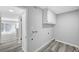 Spacious laundry room features connections, wood-look flooring, and storage cabinets at 3791 El Camino Rd, Las Vegas, NV 89103