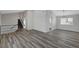 Bright living room with wood floors and a modern chandelier over the stairs at 3791 El Camino Rd, Las Vegas, NV 89103