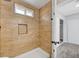 Beautifully tiled shower area with a built-in niche and updated door at 3791 El Camino Rd, Las Vegas, NV 89103