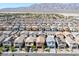 Expansive aerial showcases a dense neighborhood near mountains, featuring uniform homes, and desert landscape at 3808 Seyfert Ave, North Las Vegas, NV 89084