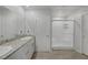Bright bathroom featuring double sinks, granite countertops, and a glass-enclosed shower stall at 3808 Seyfert Ave, North Las Vegas, NV 89084