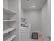Well-lit laundry room features shelving and a new, white, front-loading washer and dryer at 3808 Seyfert Ave, North Las Vegas, NV 89084