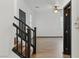 Stylish hallway with hardwood stairs, black railing, and wood-look tile flooring throughout at 4517 Lime Straight Dr, Las Vegas, NV 89115