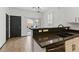 Kitchen features bar seating, stone countertops, access to the backyard, and wood flooring at 4517 Lime Straight Dr, Las Vegas, NV 89115