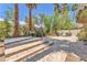 Spacious backyard patio with desert landscaping, trees, and block wall at 465 Indigo Springs St, Henderson, NV 89014