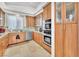 Contemporary kitchen with wood cabinets, updated appliances, and a decorative mosaic backsplash at 465 Indigo Springs St, Henderson, NV 89014