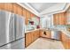 Modern kitchen boasting stainless steel appliances, wood cabinetry, and a stylish mosaic backsplash at 465 Indigo Springs St, Henderson, NV 89014