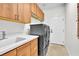 Laundry room with modern appliances, built-in cabinets, a sink, and tile floors at 465 Indigo Springs St, Henderson, NV 89014