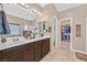 A bathroom boasts double sinks, granite countertops, dark wood cabinets, and a walk-in closet at 5226 Lignum Ave # 1, Pahrump, NV 89061