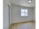 Bright bedroom features wood floors, closet, and a window bringing in natural light at 5273 Manassas Ave, Las Vegas, NV 89122