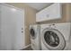 Convenient laundry room with washer, dryer, and overhead cabinets for easy organization and storage at 544 Rancho Del Sol Way, North Las Vegas, NV 89031