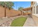 Well-maintained backyard with a covered patio, artificial turf, river rock landscaping and block wall at 5731 Sedona Springs St, North Las Vegas, NV 89031