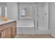 Bright bathroom with a large soaking tub, glass shower, single vanity, and tile flooring, creating a spa-like experience at 5731 Sedona Springs St, North Las Vegas, NV 89031