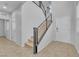 Modern hallway featuring gray walls, tile flooring, a white front door, and sleek metal railings on the stairs at 5731 Sedona Springs St, North Las Vegas, NV 89031