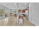 Open kitchen with stainless steel appliances, brown cabinets, and an island with a sink at 5731 Sedona Springs St, North Las Vegas, NV 89031