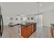 Open-concept kitchen and living space featuring a breakfast bar, tile flooring, and modern appliances at 6130 Yuzu Pl, Las Vegas, NV 89122