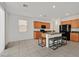 A well-lit kitchen featuring wood cabinets, granite countertops, a breakfast bar, and stainless steel appliances at 6130 Yuzu Pl, Las Vegas, NV 89122