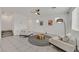 Bright living room with tile flooring, modern decor, and two comfortable chairs flanking a golden accent table at 6130 Yuzu Pl, Las Vegas, NV 89122