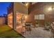 Picturesque backyard with a covered patio, outdoor dining area, lush plants, and well-maintained artificial turf at 6546 American Flower St, Las Vegas, NV 89148