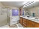 Bathroom with dual sinks, soaking tub, and glass-enclosed shower at 6546 American Flower St, Las Vegas, NV 89148