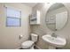Powder room featuring a pedestal sink and toilet with a window at 6546 American Flower St, Las Vegas, NV 89148