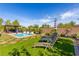 Relaxing backyard with a pool, artificial turf, lounge chairs, and a charming compass wall decor at 7340 Orchard Harvest Ave, Las Vegas, NV 89131