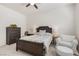Bedroom with a ceiling fan, a dark wooden bed frame, dresser, chair and an ottoman at 7340 Orchard Harvest Ave, Las Vegas, NV 89131