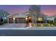 Beautiful single-story home with a three-car garage featuring outdoor lighting at 7340 Orchard Harvest Ave, Las Vegas, NV 89131