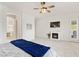 Spacious main bedroom with a fireplace, ceiling fan, and an ensuite bathroom visible through the archway at 7340 Orchard Harvest Ave, Las Vegas, NV 89131
