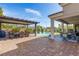 Expansive brick patio with pergola, dining area, and inviting views of the pool and lush landscaping at 7340 Orchard Harvest Ave, Las Vegas, NV 89131