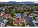 Stunning aerial view of a neighborhood with lush landscaping, pools, and mountain views in the distance at 7521 Dry Pines Cir, Las Vegas, NV 89129