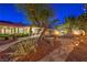Beautifully landscaped backyard with stone pathways, mature trees, and exterior lighting at 7521 Dry Pines Cir, Las Vegas, NV 89129